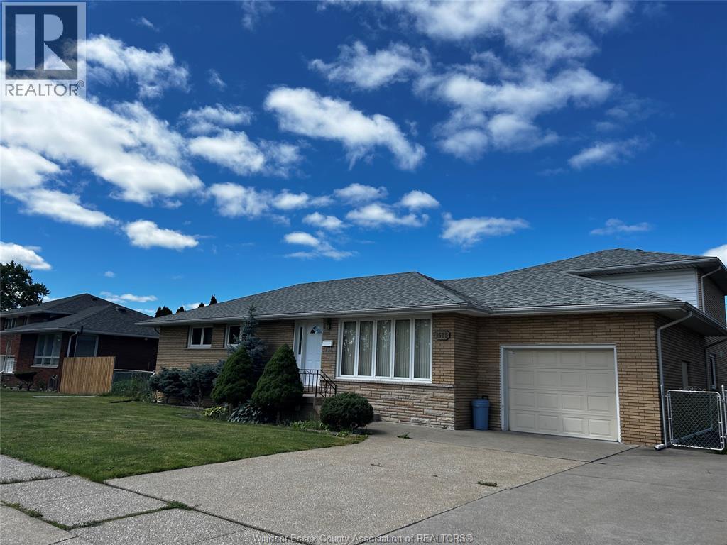 A house with a garage and a driveway in front of it.