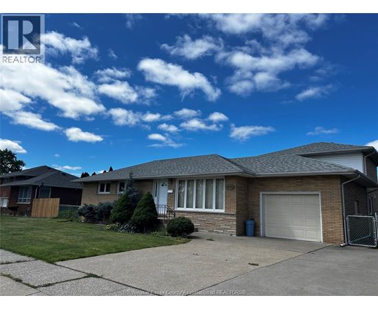 A house with a garage and a driveway in front of it.