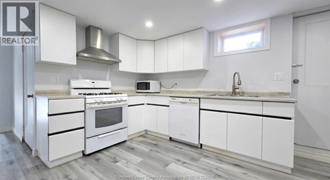 A kitchen with white cabinets and appliances is on the market.