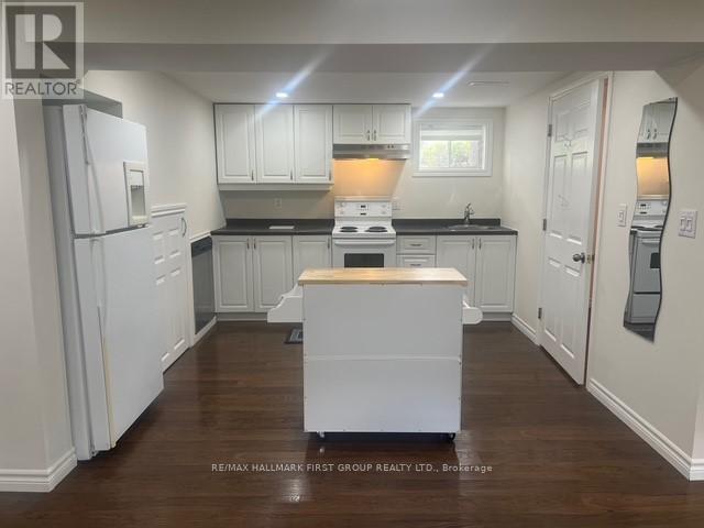 A kitchen with white cabinets and a wooden island.