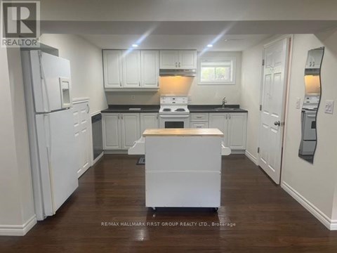 A kitchen with white cabinets and a wooden island.