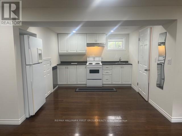 A kitchen with white cabinets and a black countertop.
