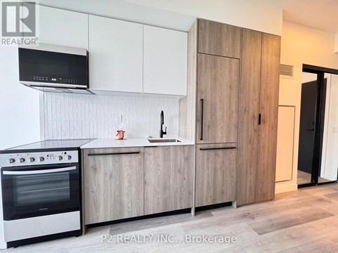 A modern kitchen with wooden cabinets and a stainless steel oven.