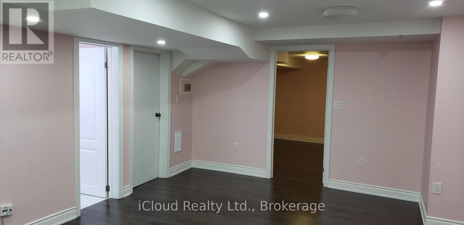 A room with pink walls and a wooden door.