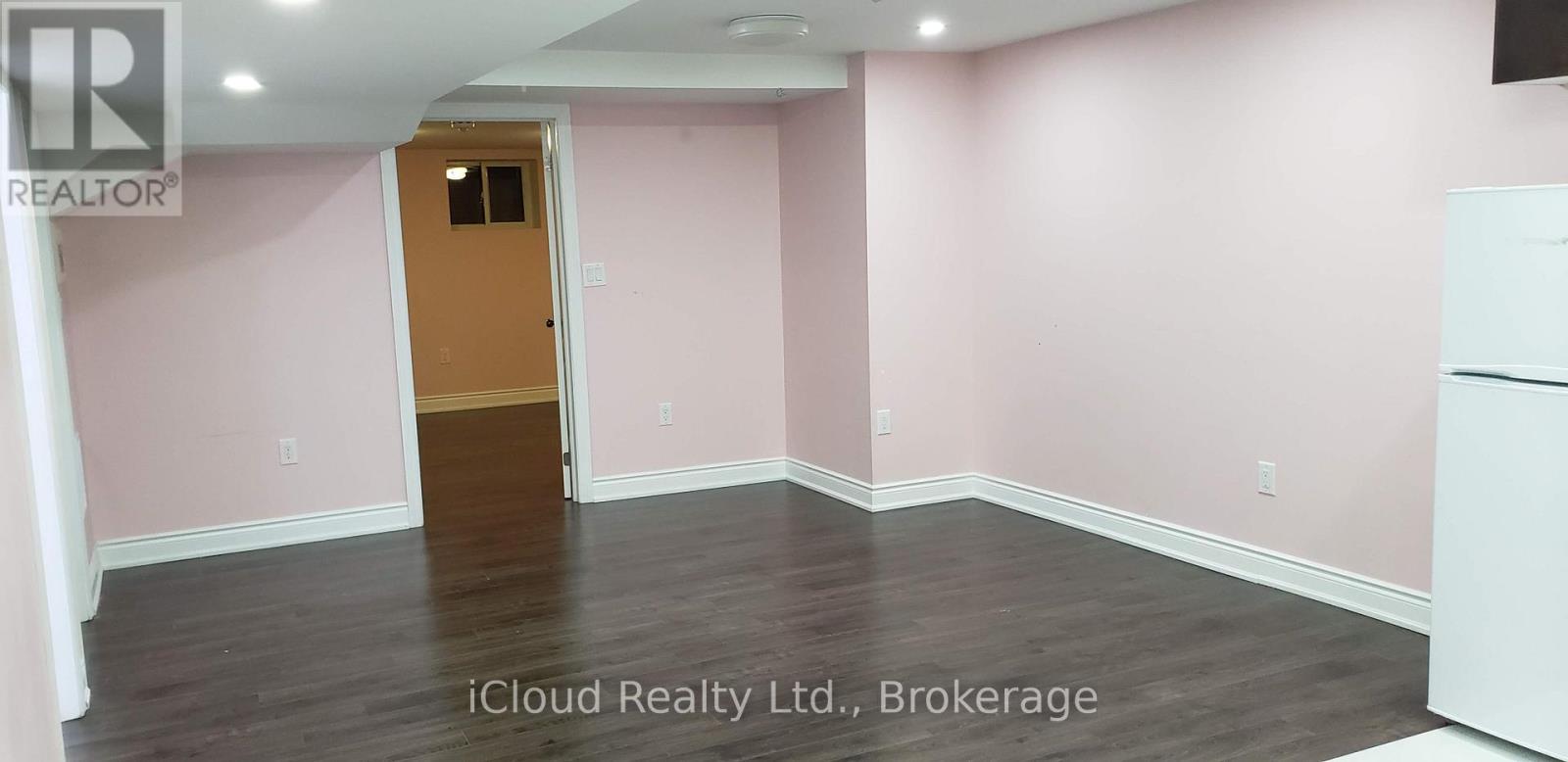 A room with pink walls and a wooden door.