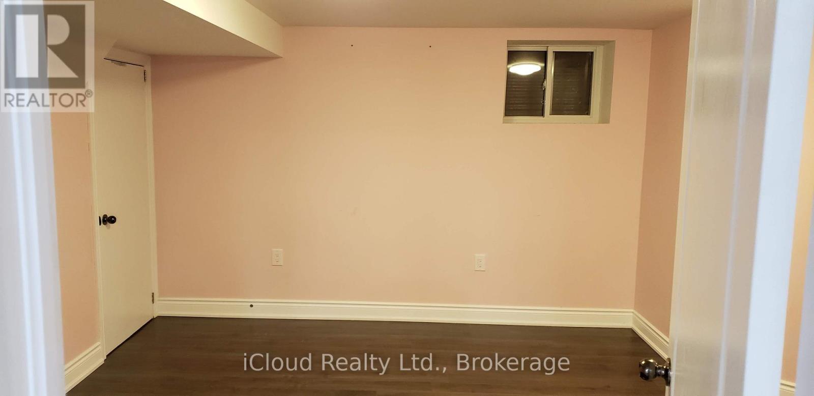 A room with a pink wall and a window.