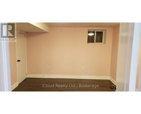 A room with a pink wall and a window.