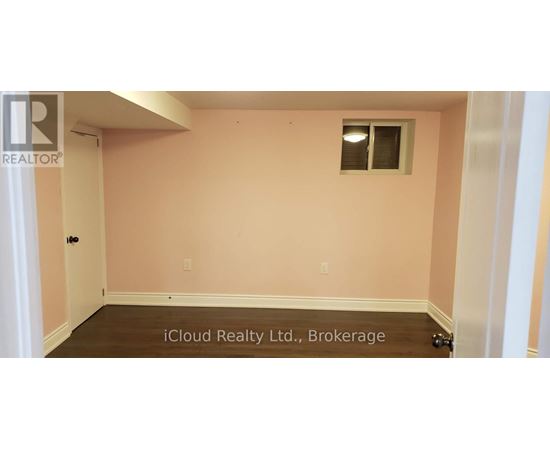 A room with a pink wall and a window.