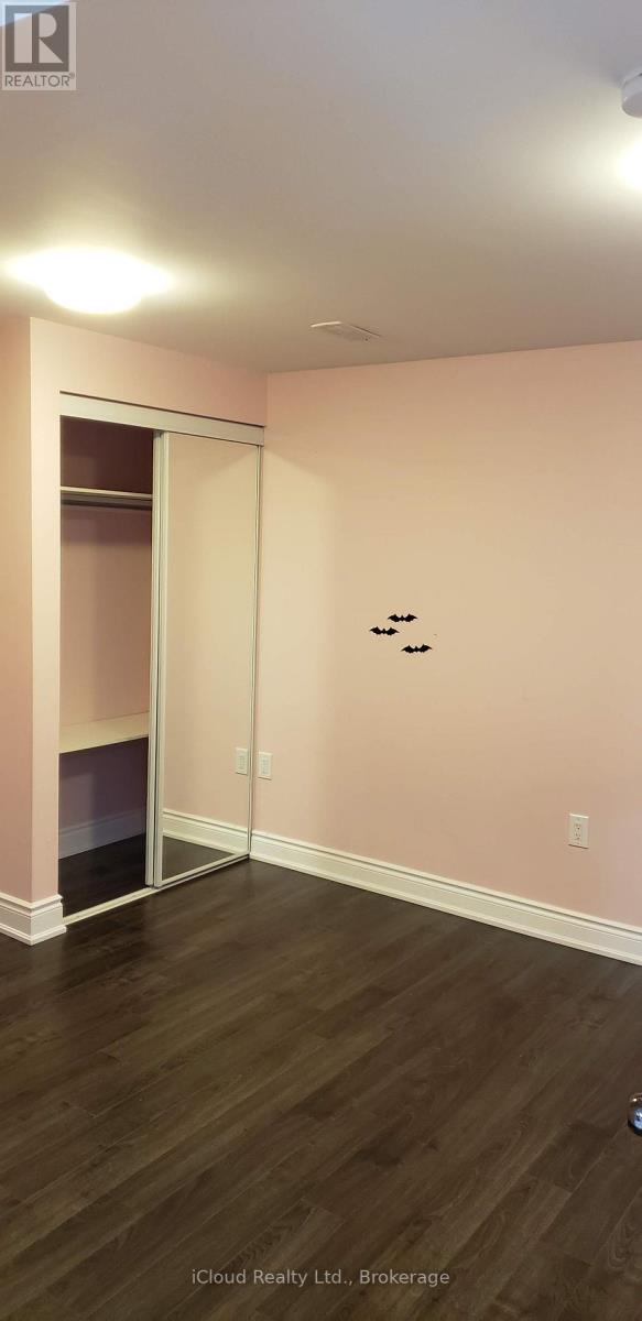 A room with a pink wall and a wooden floor.