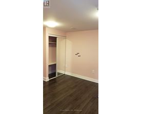 A room with a pink wall and a wooden floor.