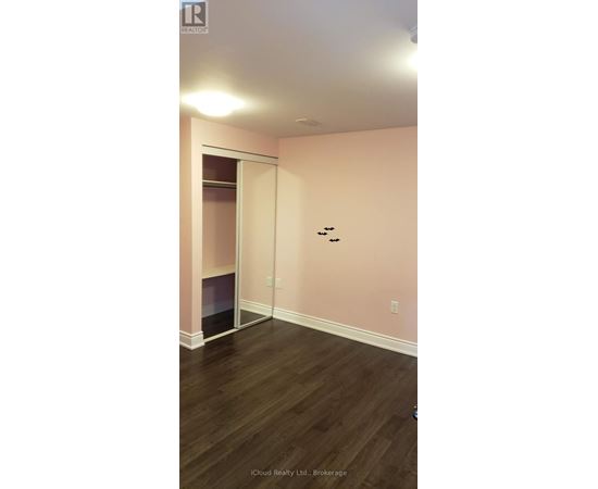 A room with a pink wall and a wooden floor.