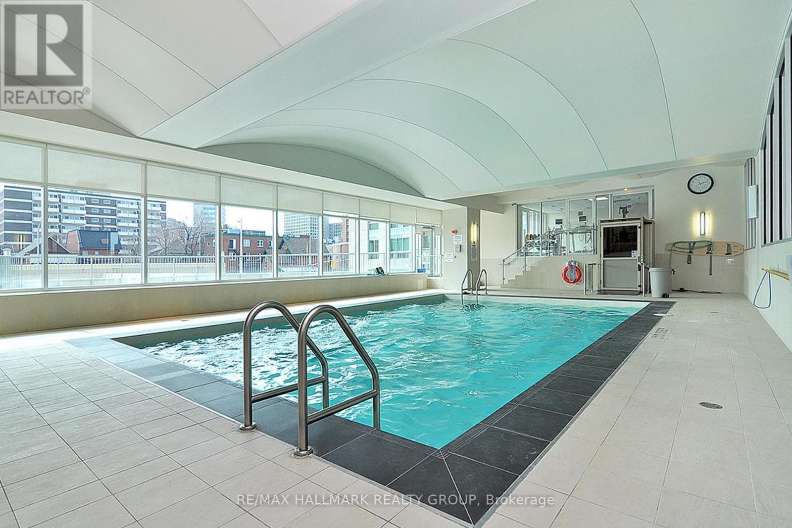 A large indoor swimming pool with a diving board.