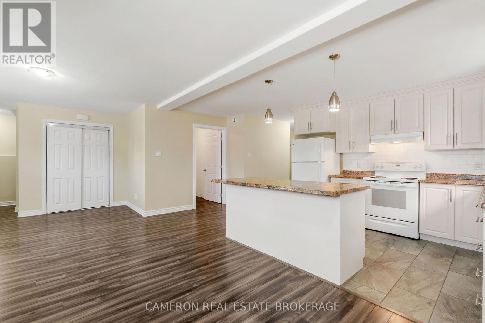 A kitchen with white cabinets and a wooden island.
