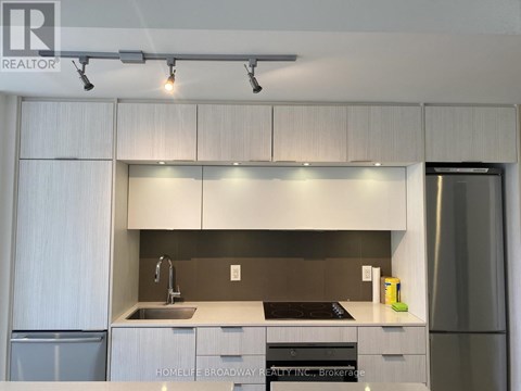 A modern kitchen with white cabinets and stainless steel appliances.