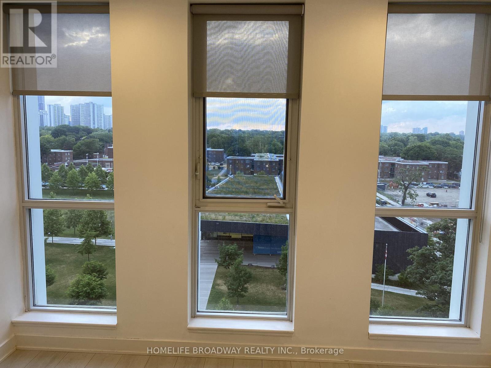 Three windows overlooking a cityscape with trees and buildings.