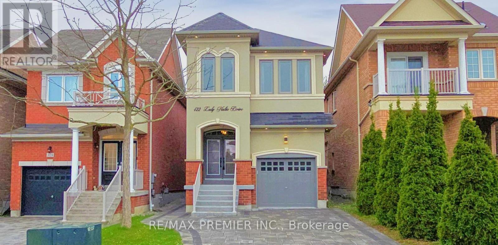A row of houses with the RE/MAX Premier Inc. Brokerage logo in the foreground.