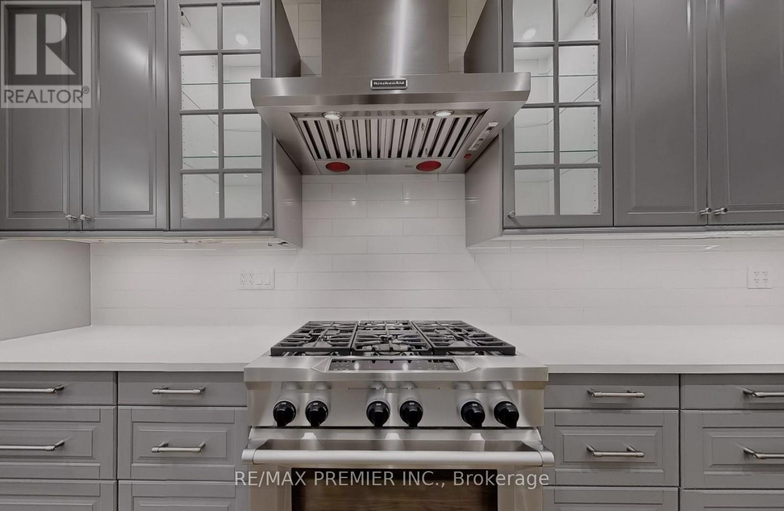 A modern kitchen with a stove top oven and cabinets.