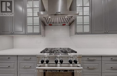 A modern kitchen with a stove top oven and cabinets.