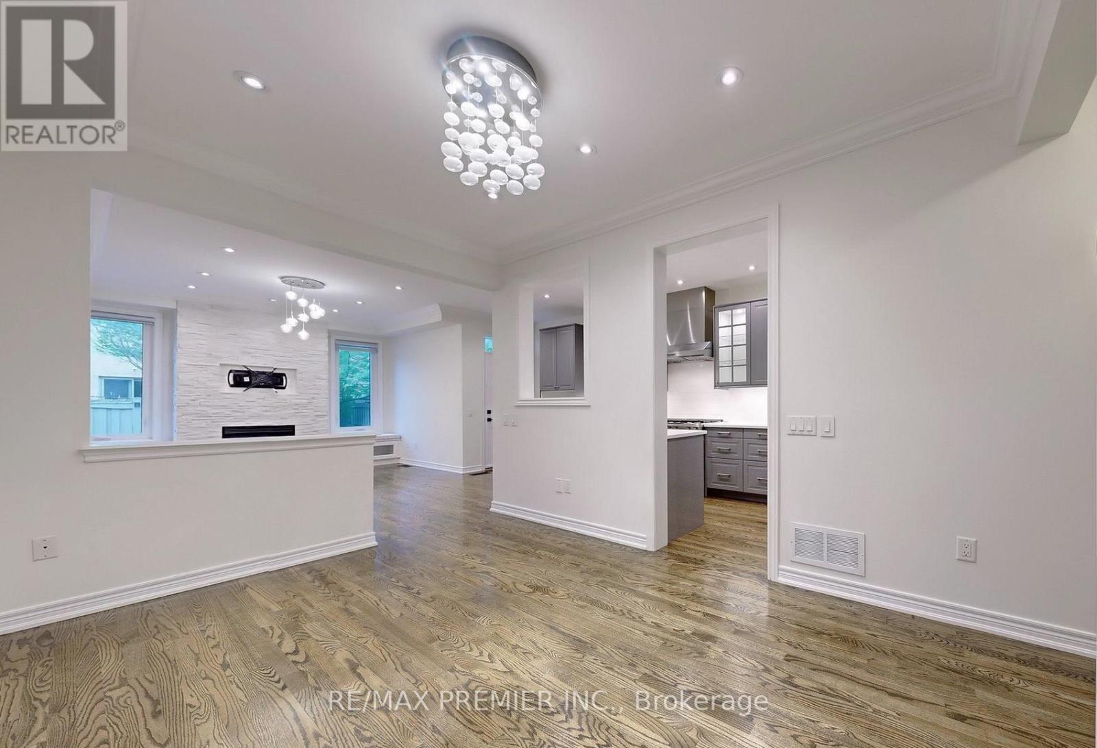 A spacious room with wooden flooring and a chandelier.