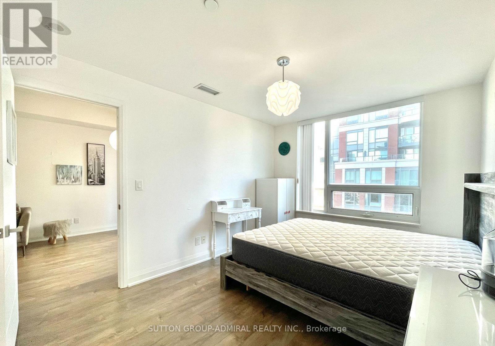 A bedroom with a large bed and a window overlooking a city.