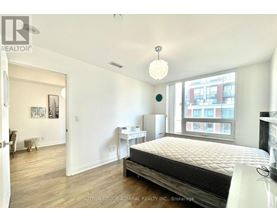 A bedroom with a large bed and a window overlooking a city.