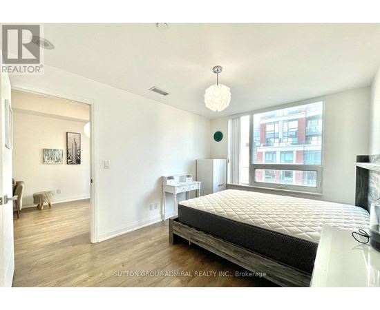 A bedroom with a large bed and a window overlooking a city.