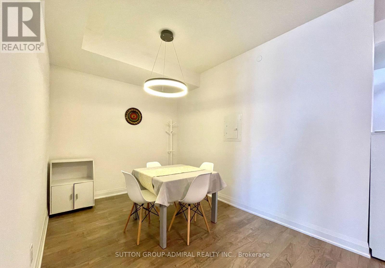 A dining room with a white table and chairs.