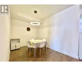 A dining room with a white table and chairs.