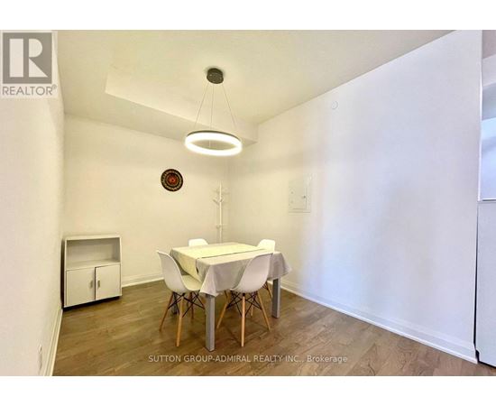 A dining room with a white table and chairs.