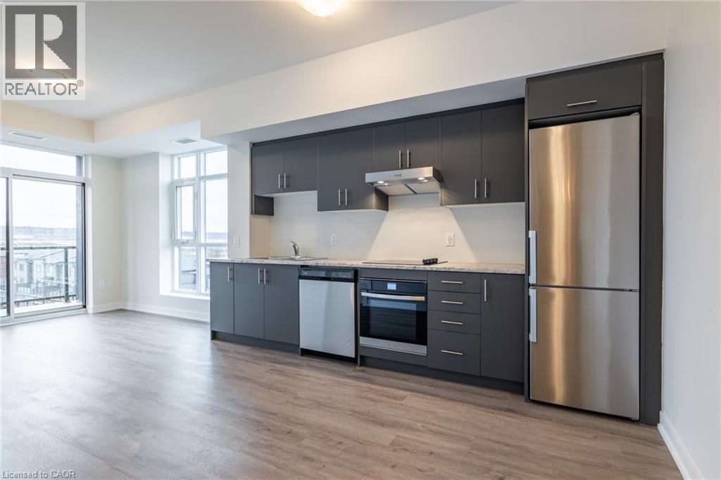 A modern kitchen with dark grey cabinets and stainless steel appliances.