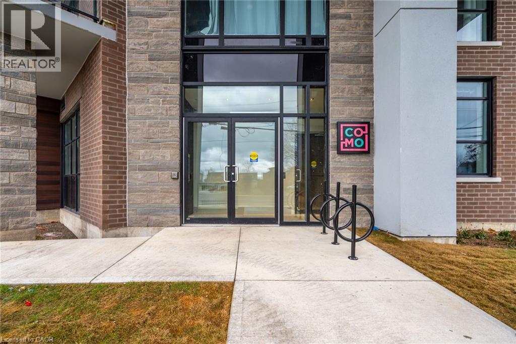 The entrance to a building with a glass door and a sign that reads "COMO".