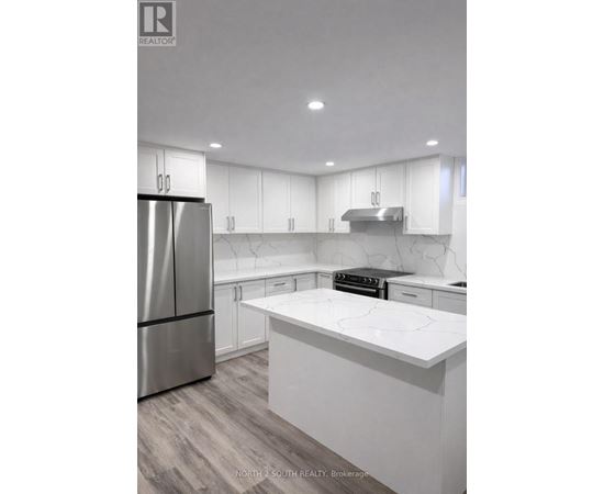 A modern kitchen with white cabinets and a marble countertop.