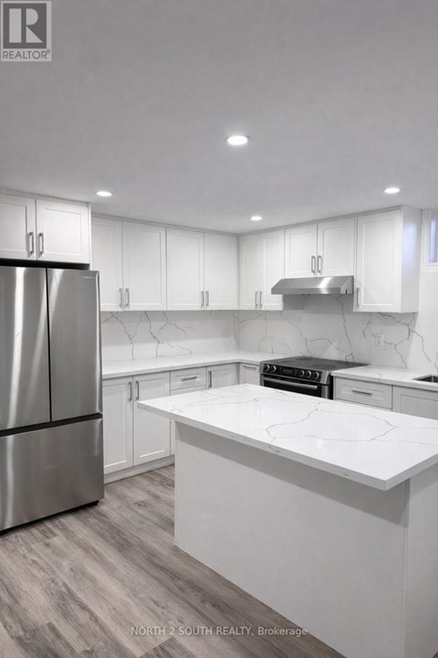 A modern kitchen with white cabinets and a marble countertop.