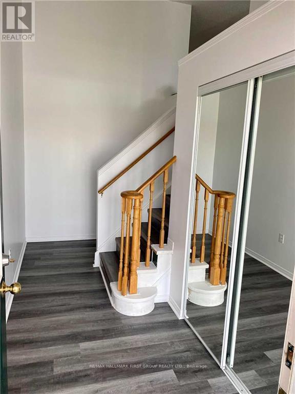 A hallway with a wooden staircase and a glass door.