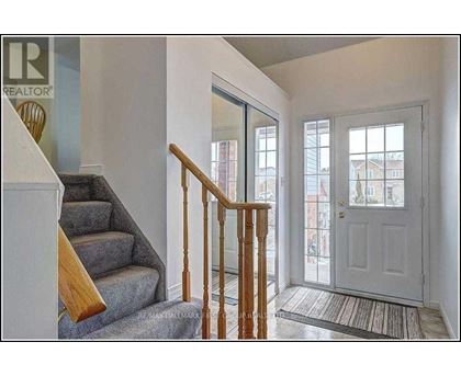 A hallway with a staircase leading to the second floor.