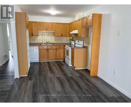 A kitchen with wooden cabinets and a white dishwasher.