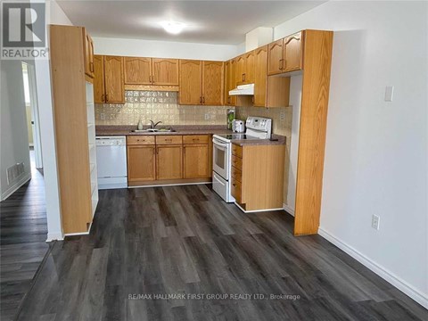 A kitchen with wooden cabinets and a white dishwasher.