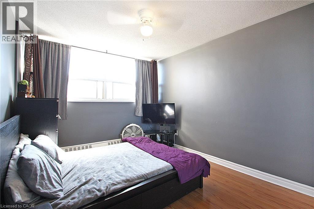 A bedroom with a bed, a fan, and a window.