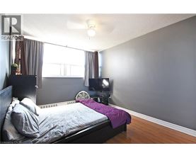 A bedroom with a bed, a fan, and a window.