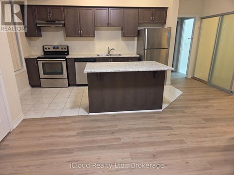 A kitchen with a white counter top and wooden floors.
