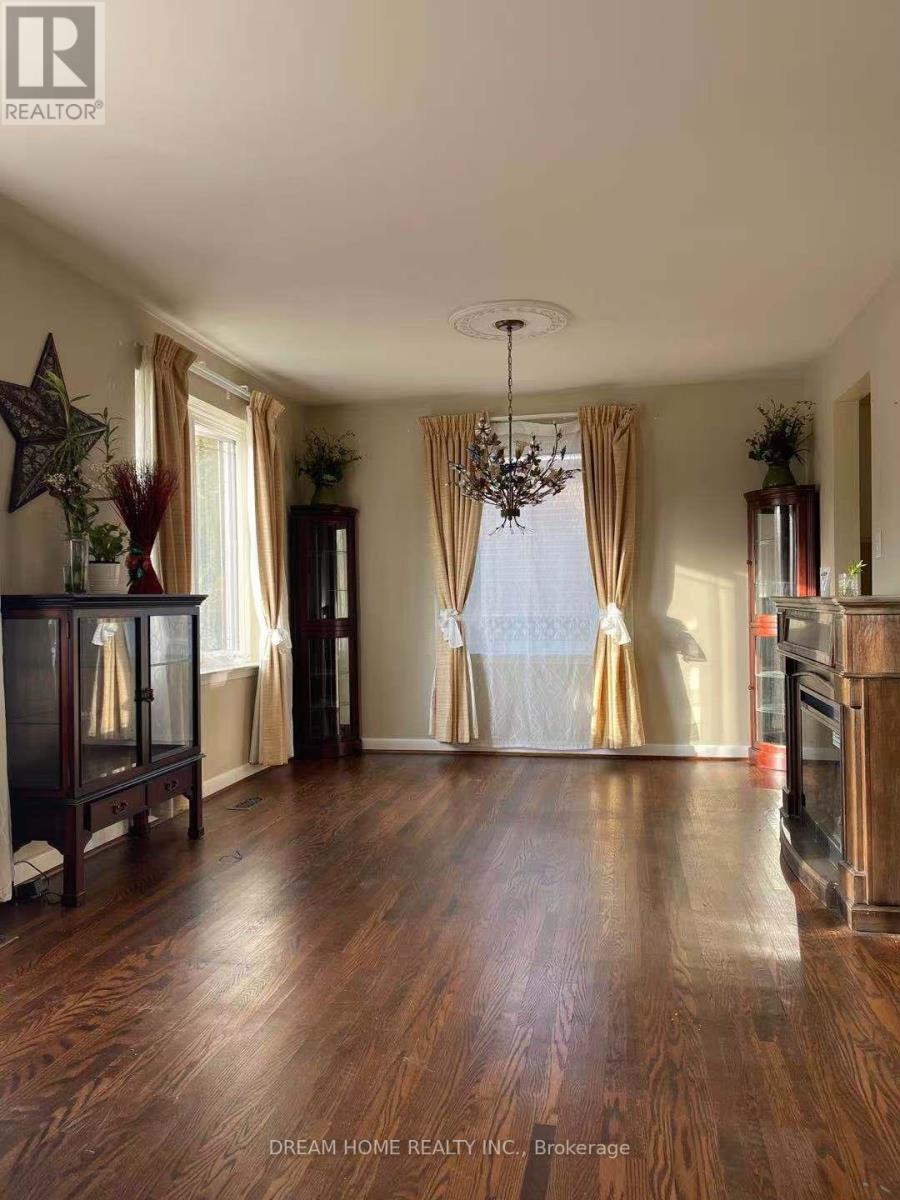 A spacious room with wooden floors and a chandelier.