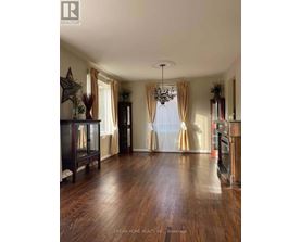 A spacious room with wooden floors and a chandelier.