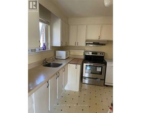 A kitchen with white cabinets and a black and white tiled floor.