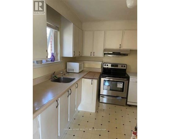 A kitchen with white cabinets and a black and white tiled floor.
