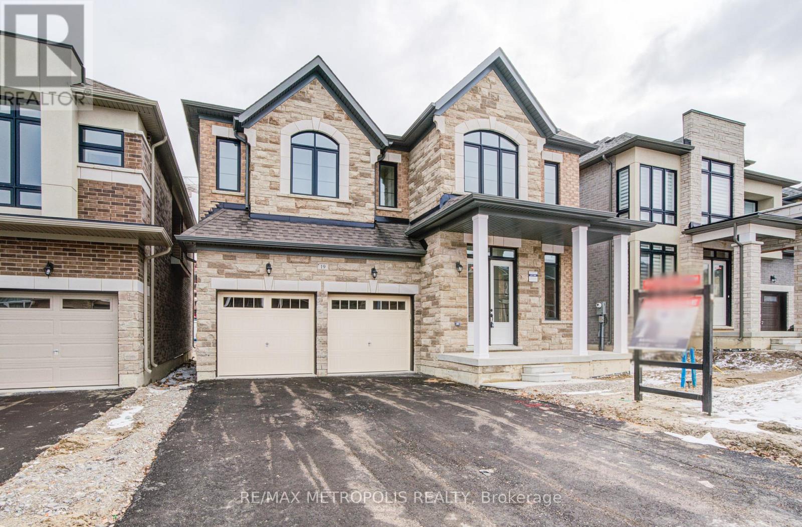 A large, multi-level house with a brick facade and a garage.