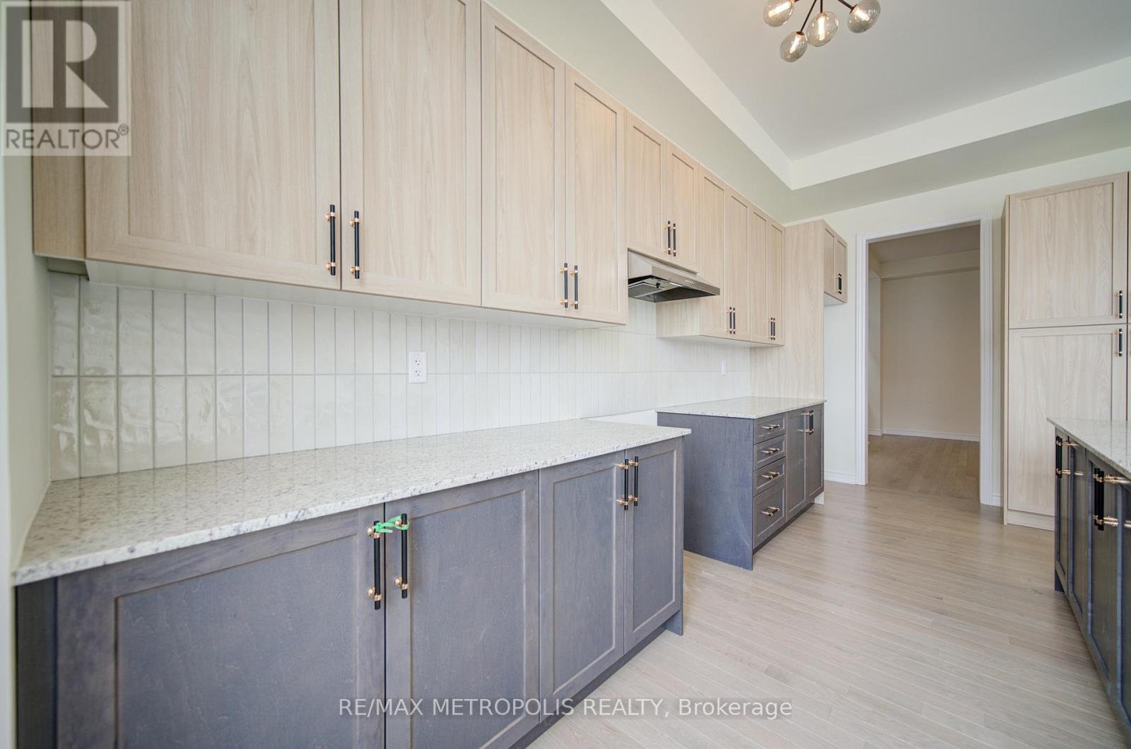 A kitchen with wooden cabinets and a marble countertop.