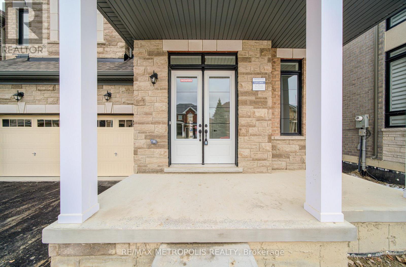 The front entrance of a building with a glass door and a sign above it.