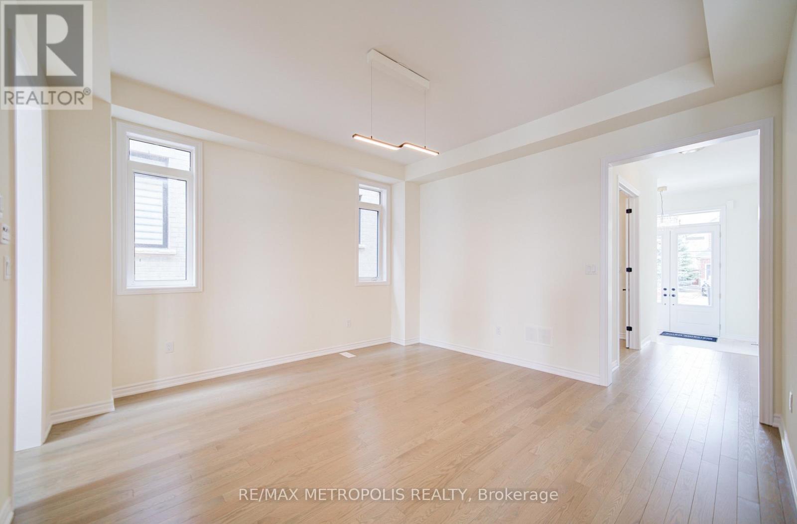 A spacious room with wooden floors and white walls.
