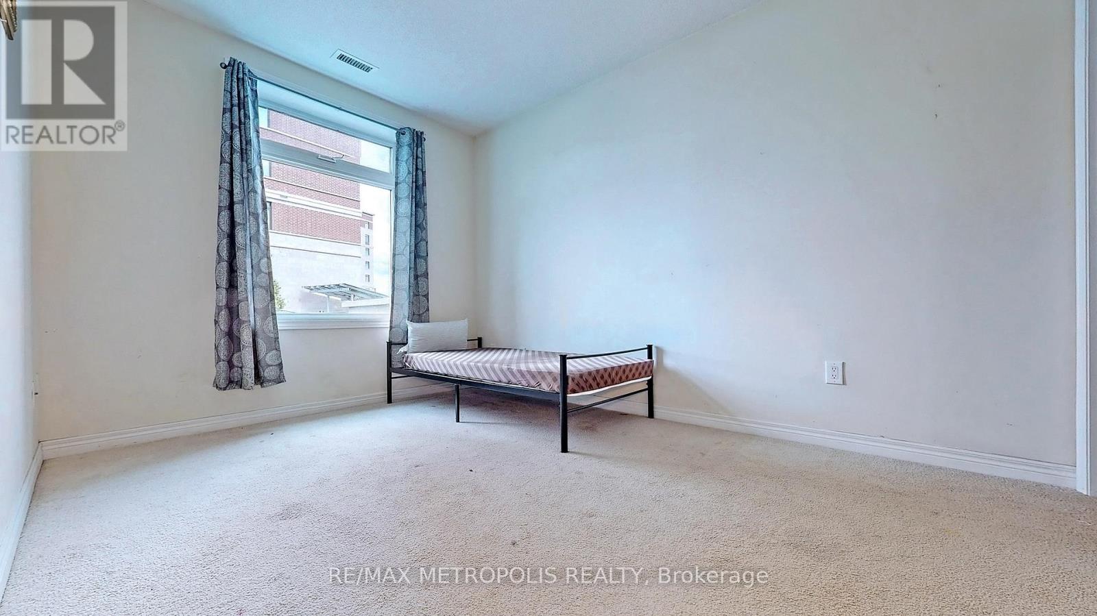 A bedroom with a bed and a window with curtains.