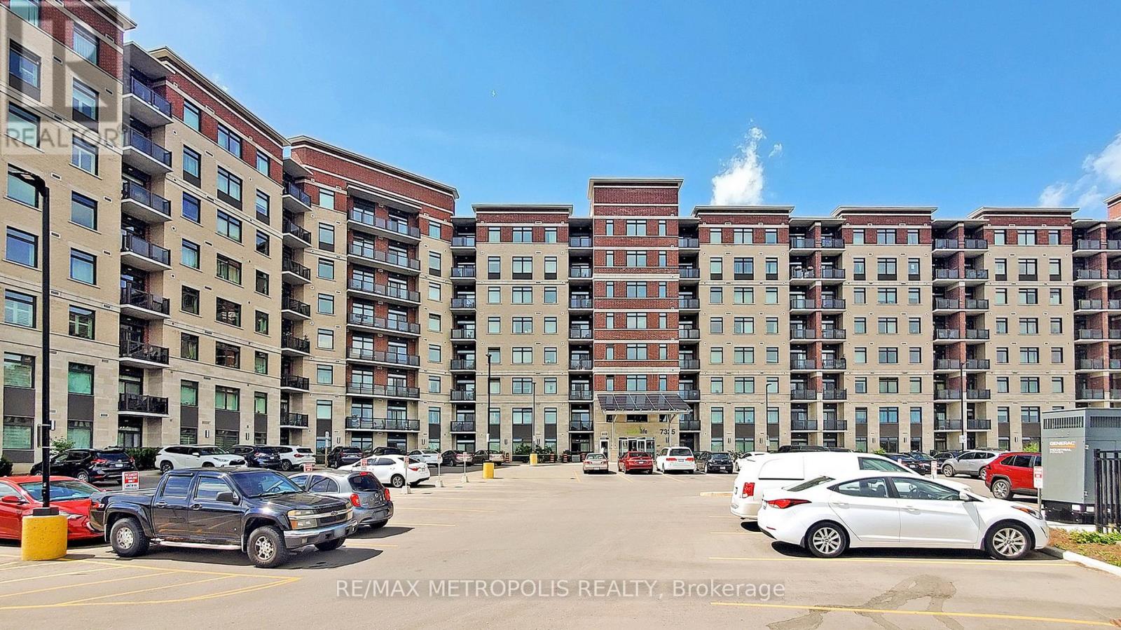 A parking lot with cars and apartment buildings in the background.